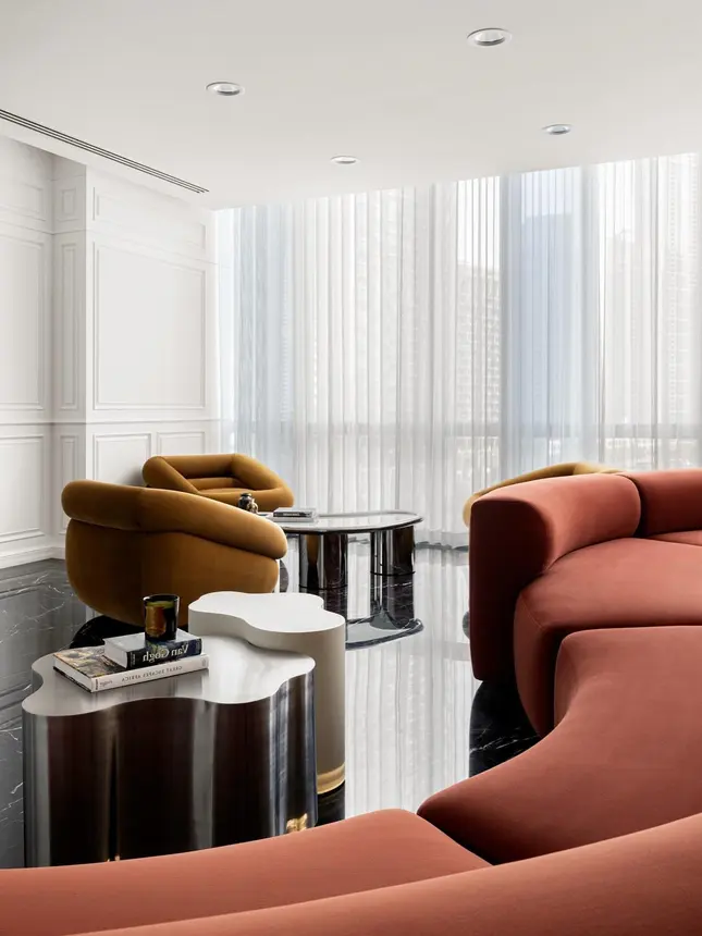 Baltos dieninės užuolaidos per visą sieną svetainėje su terakotos spalvos lenkta sofa